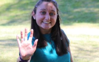 MaryClaire holds her hand out in a high-five, which is the logo for ɫƵ Peer Mentors