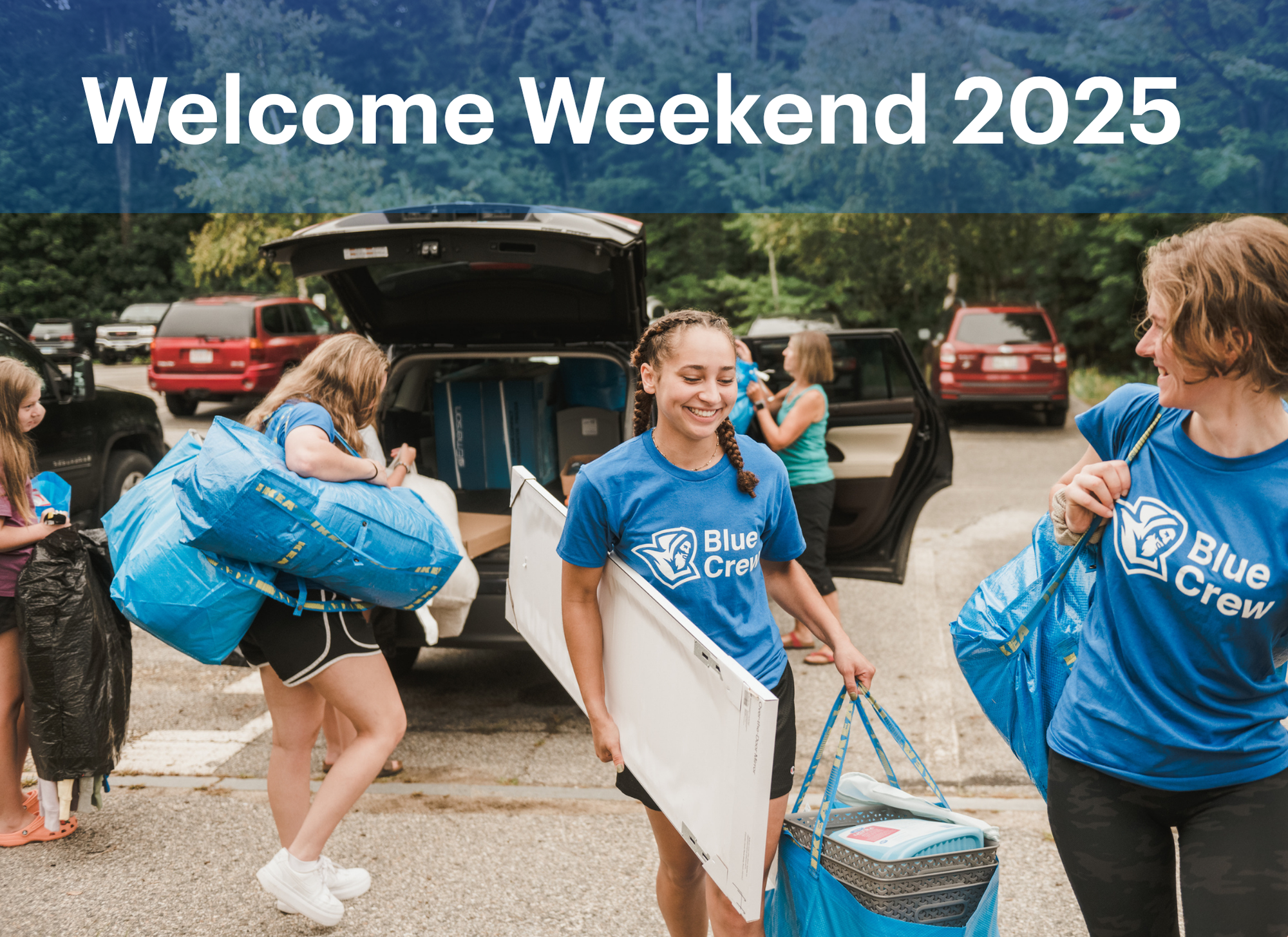 Students in matching Blue Crew shirts help unload belongings from cars during Move In Weekend, with trees and parked vehicles in the background. Saint Joseph's College of Maine