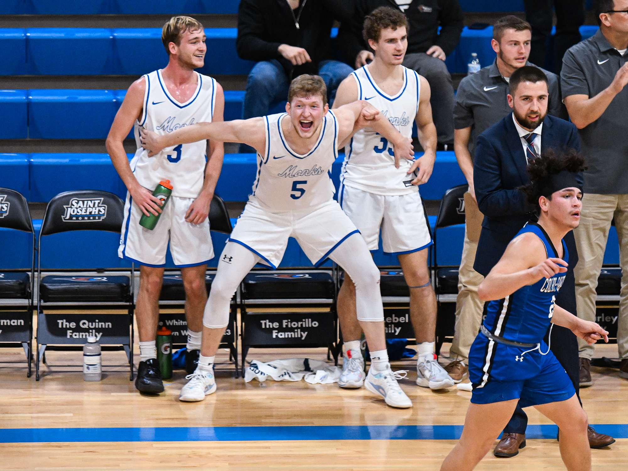 Monks men's basketball players cheer their fellow athletes during a game!