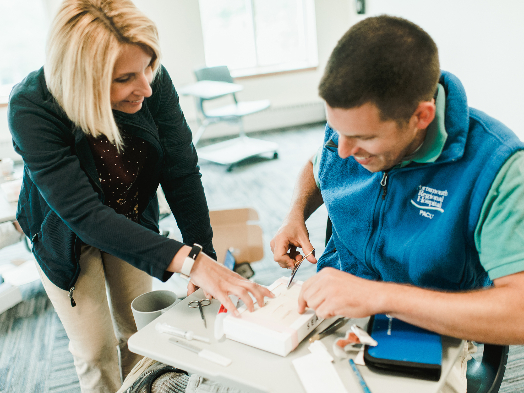 Nursing faculty works one-on-one with online nurse practitioner student honing their suturing skills.